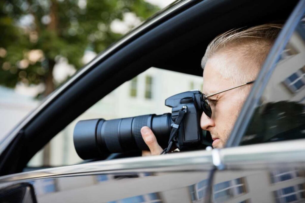 A man capturing a moment with his camera while seated in a car.